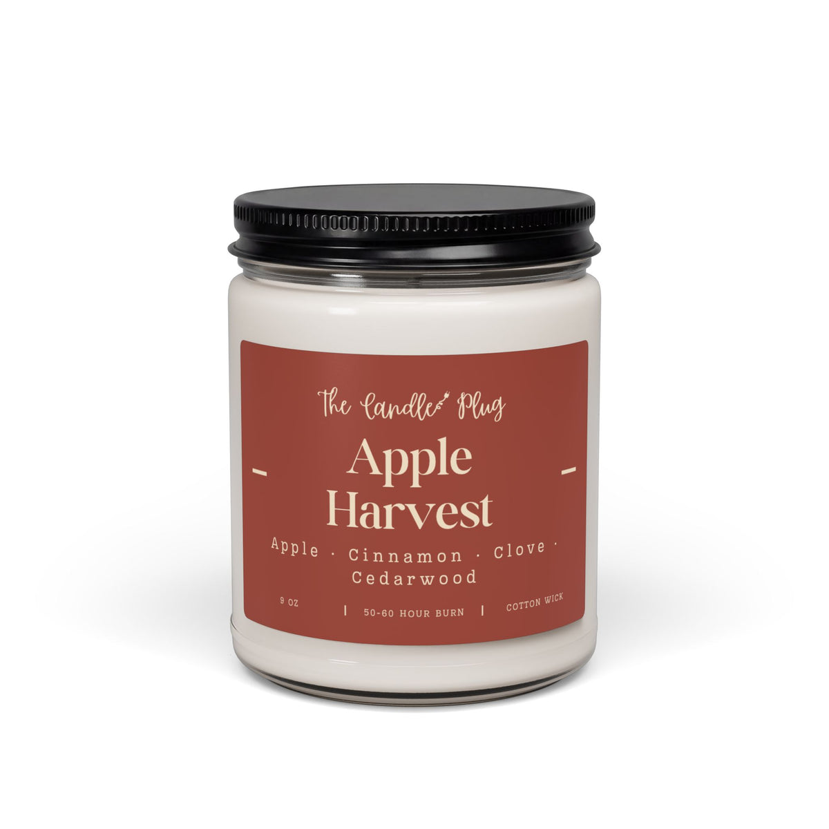 A fall candle with white wax, a black metal lid, and a dusty rose label reading 'The Candle Plug' and 'Apple Harvest' on a clean white background.