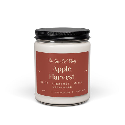 A fall candle with white wax, a black metal lid, and a dusty rose label reading 'The Candle Plug' and 'Apple Harvest' on a clean white background.