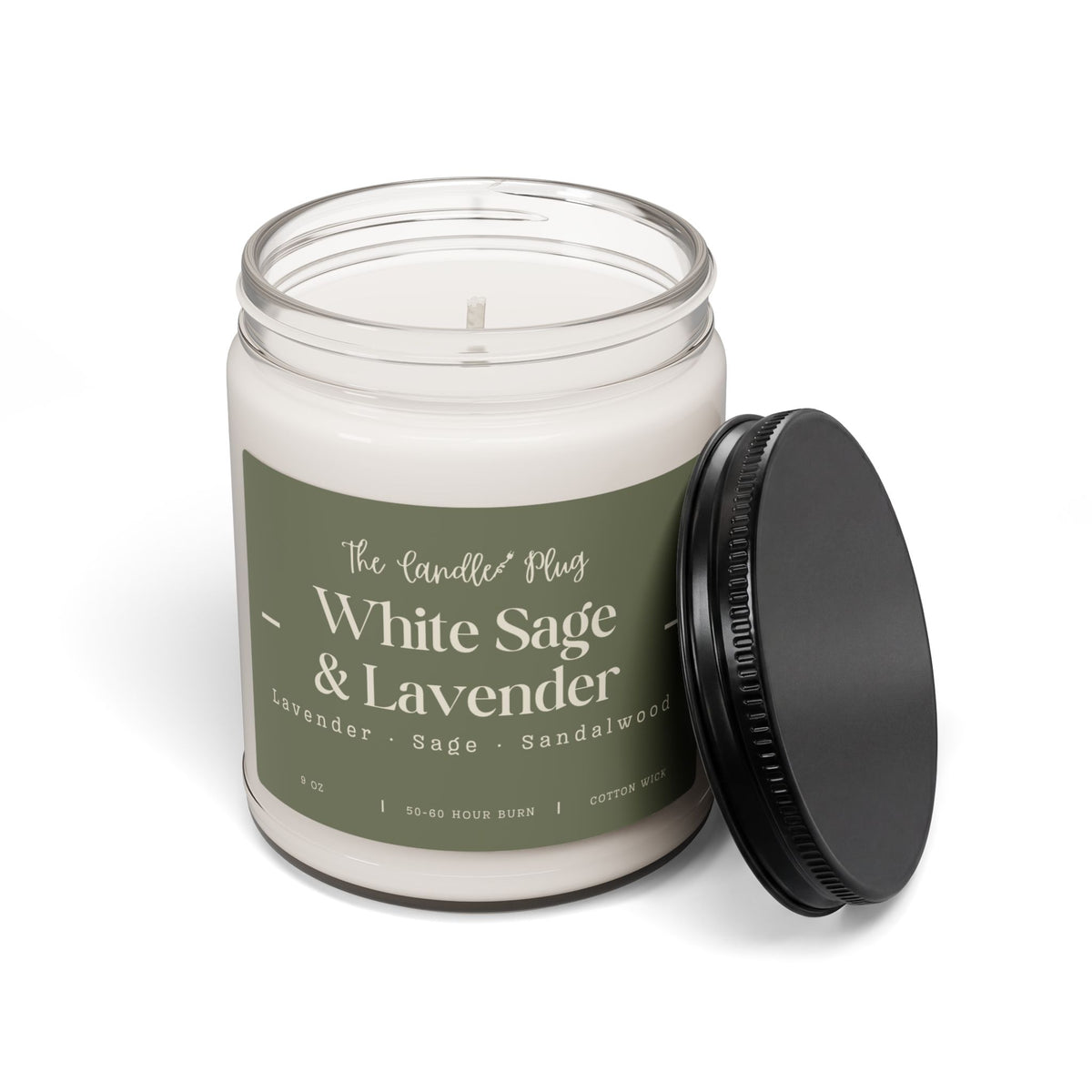 A jar candle with white wax in a clear glass container, featuring a muted sage green label that reads 'White Sage & Lavender' and 'The Candle Plug.' A black screw-top lid leans against the right side of the jar on a clean white background.