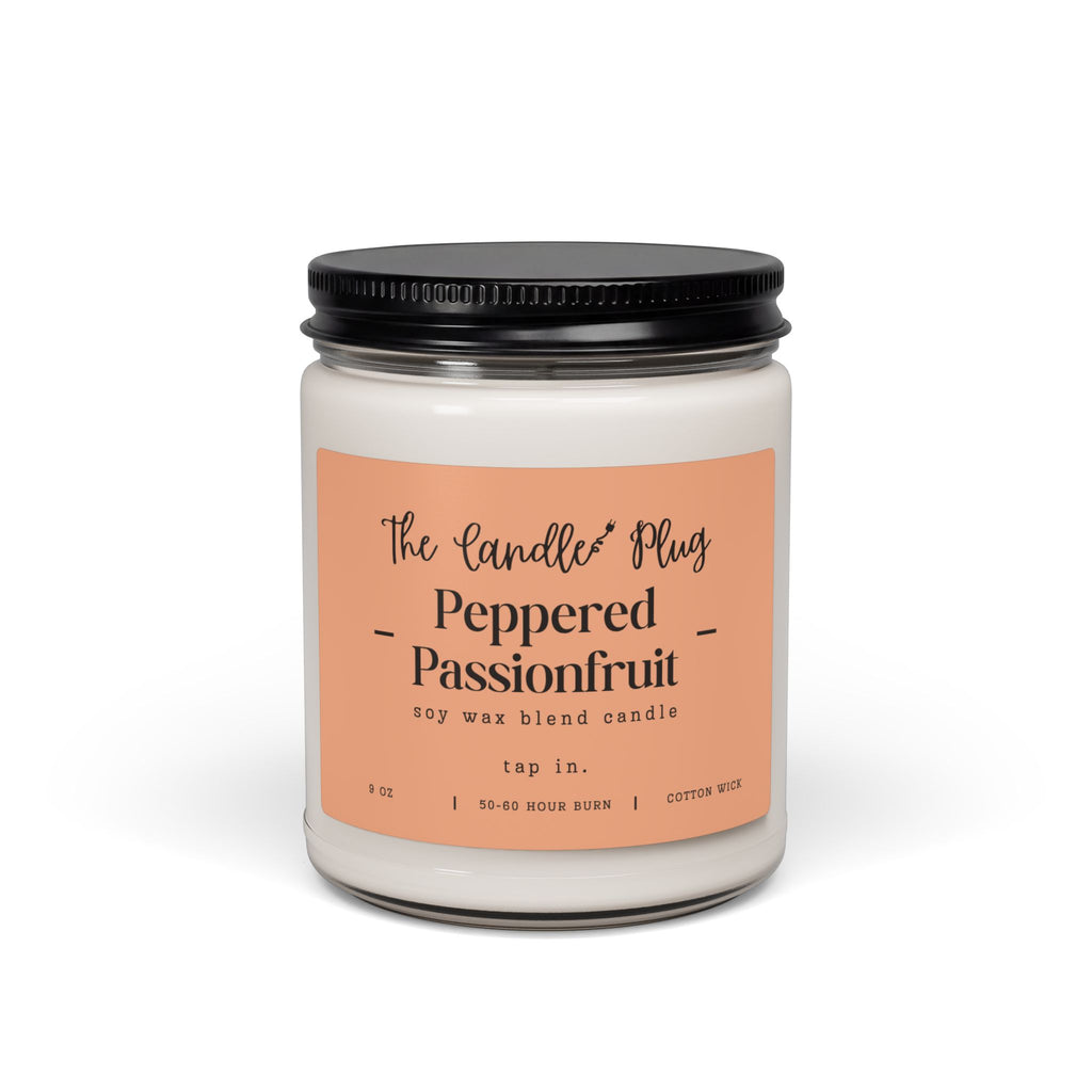 A 9 oz Peppered Passionfruit soy candle in a clear glass jar with a black metal lid and a peach-colored label. The label reads 'The Candle Plug' and 'Peppered Passionfruit'.