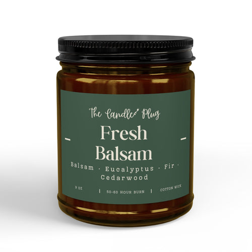 A jar candle with amber glass, a dark green label reading 'The Candle Plug Fresh Balsam', and a black screw-top lid, shown on a clean white background.